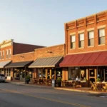 A vibrant main street in a small town with local businesses like a cafe and boutique, illustrating opportunities for small town business ideas and local entrepreneurship.