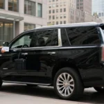 Professional NYC black car service chauffeur picking up a business traveler in a luxury SUV outside a Manhattan office building