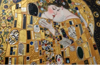 Gustav Klimt's most famous painting, The Kiss (1907-1908), a Golden Phase masterpiece in oil and gold leaf on canvas, on display at the Belvedere Museum in Vienna, Austria. The painting depicts an intimate, embracing couple adorned in elaborate golden geometric and floral patterns.