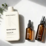Kevin Murphy hair products arranged on marble surface including Hydrate-Me shampoo and conditioner, Young Again treatment oil, and styling spray for healthy, voluminous hair.