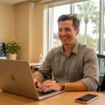 Young business owner working on laptop at desk with Florida flag and notebook, representing small business startup guide and entrepreneurship in Florida, step-by-step process for how to start an LLC in Florida, Florida Division of Corporations Sunbiz registration, professional services and new business formation in Miami or Tampa