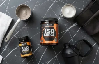 Mutant supplements product lineup including Iso Surge protein, MCT Oil, Mutant Mass, and Mutant Madness arranged on marble background with fitness accessories