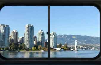 Scenic view of a BC Ferries vessel on the water approaching Vancouver skyline during a Nanaimo Vancouver commute, with a professional traveler looking out the window.