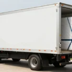 Medium-sized rental box truck being loaded with furniture and moving boxes for a household relocation, demonstrating proper cargo loading and securing techniques.